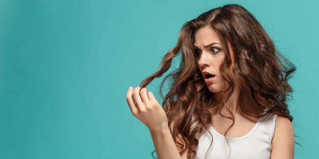 woman-upset-looking-at-ends-hair-split-ends-treatments-viviscal-blog