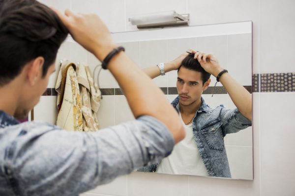 Man mirror brushing styling hair male hair loss causes prevention viviscal hair blog