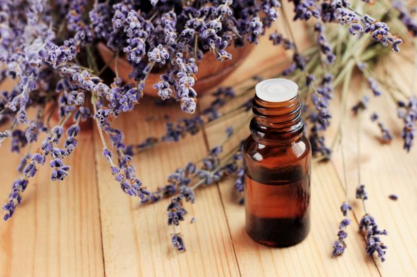 lavender essential oil brown bottle lavender flowers wooden table top lavender oil benefits for hair viviscal hair blog