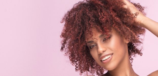 Rose gold curly hair with pink background viviscal blog