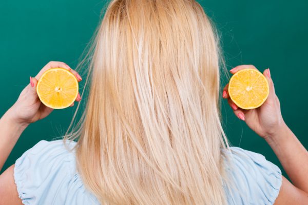 Flicka håller citron citrusfrukt